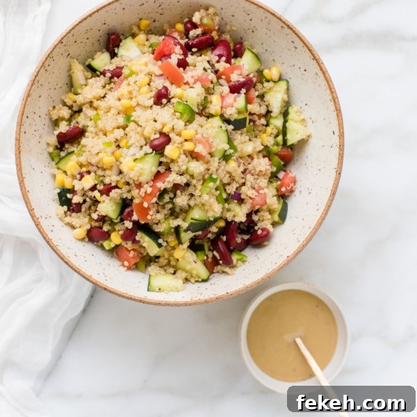 quinoa in a bowl with fresh veggies and a tahini lemon dressing