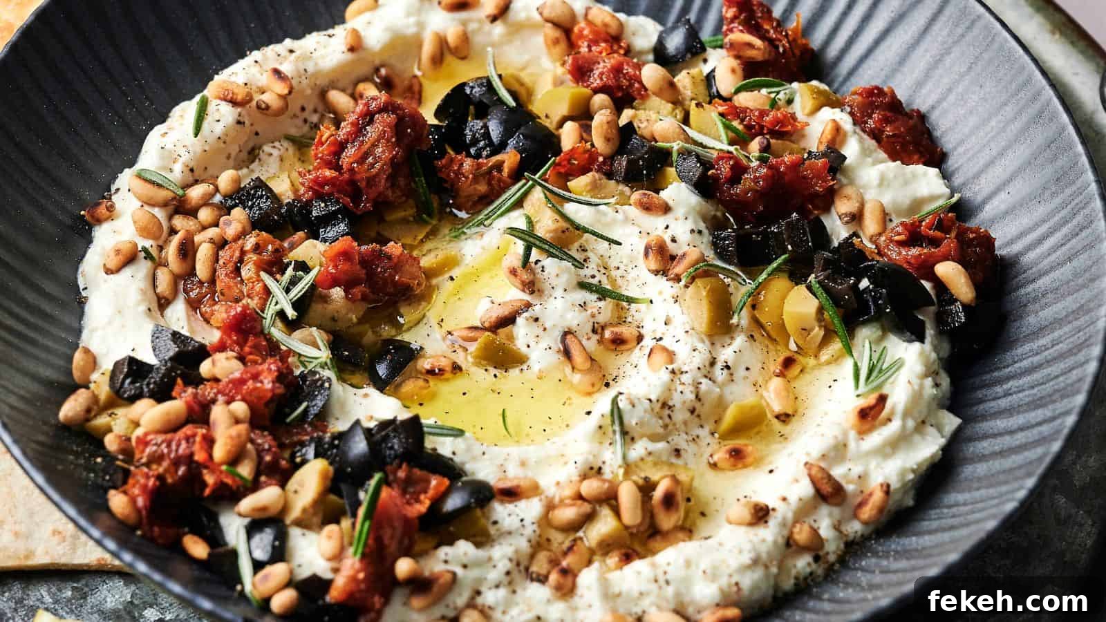I Tried 15 Fall Snacks So You Don’t Have To — Top Picks Reviewed 3 A bowl of creamy dip garnished with chopped black olives, sun-dried tomatoes, pine nuts, rosemary, olive oil, and black pepper.