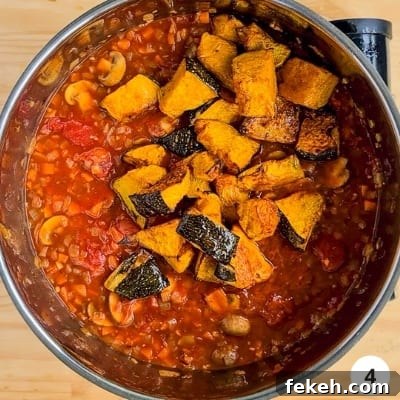 Roasted Pumpkin Vegetarian Bolognese Recipe for Cozy Dinners 7 Roasted pumpkin pieces added into pot of vegetable sauce