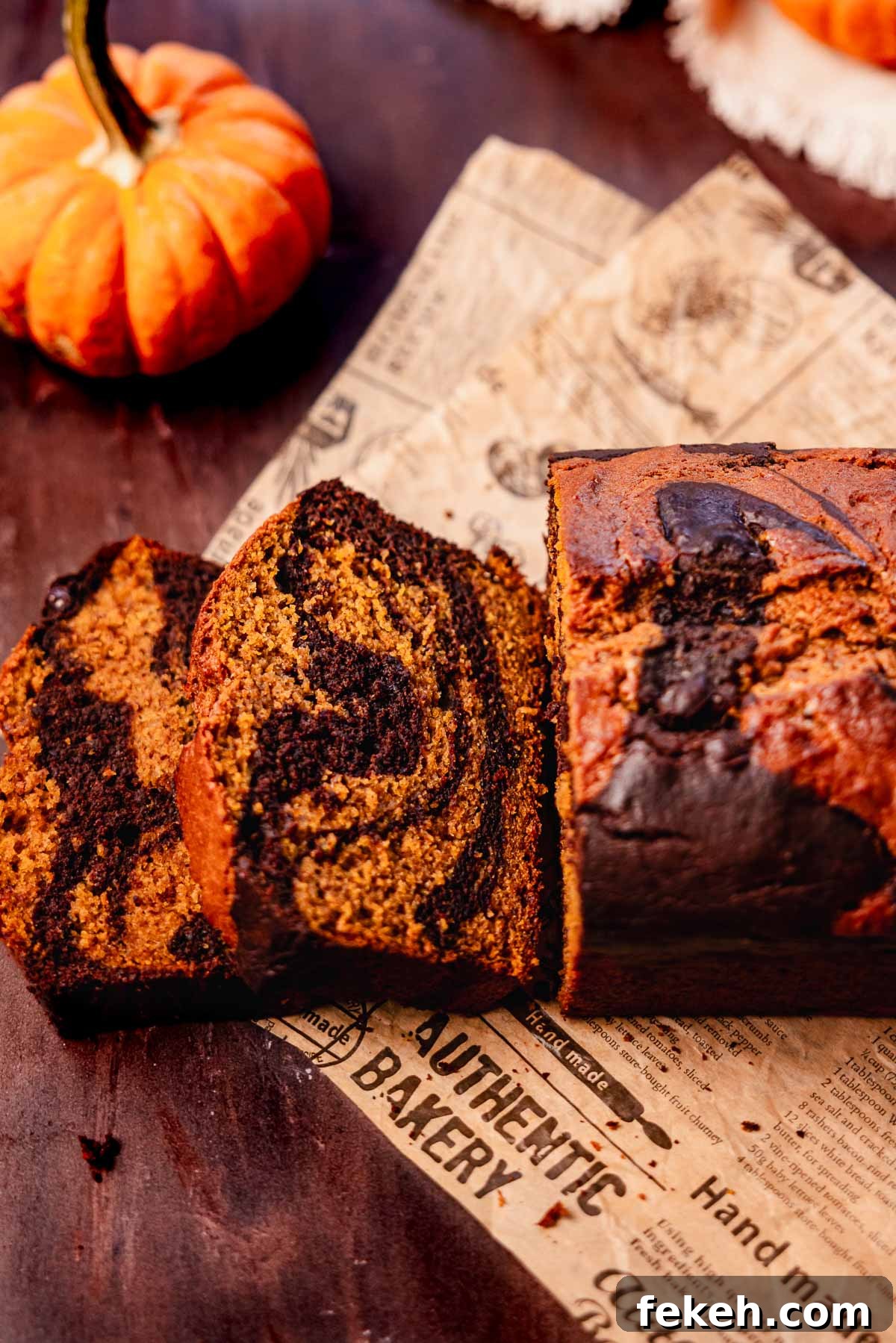 Pumpkin Chocolate Loaf with Spiced Chocolate Chips 12 sliced pumpkin and chocolate bread on brown printed parchment paper