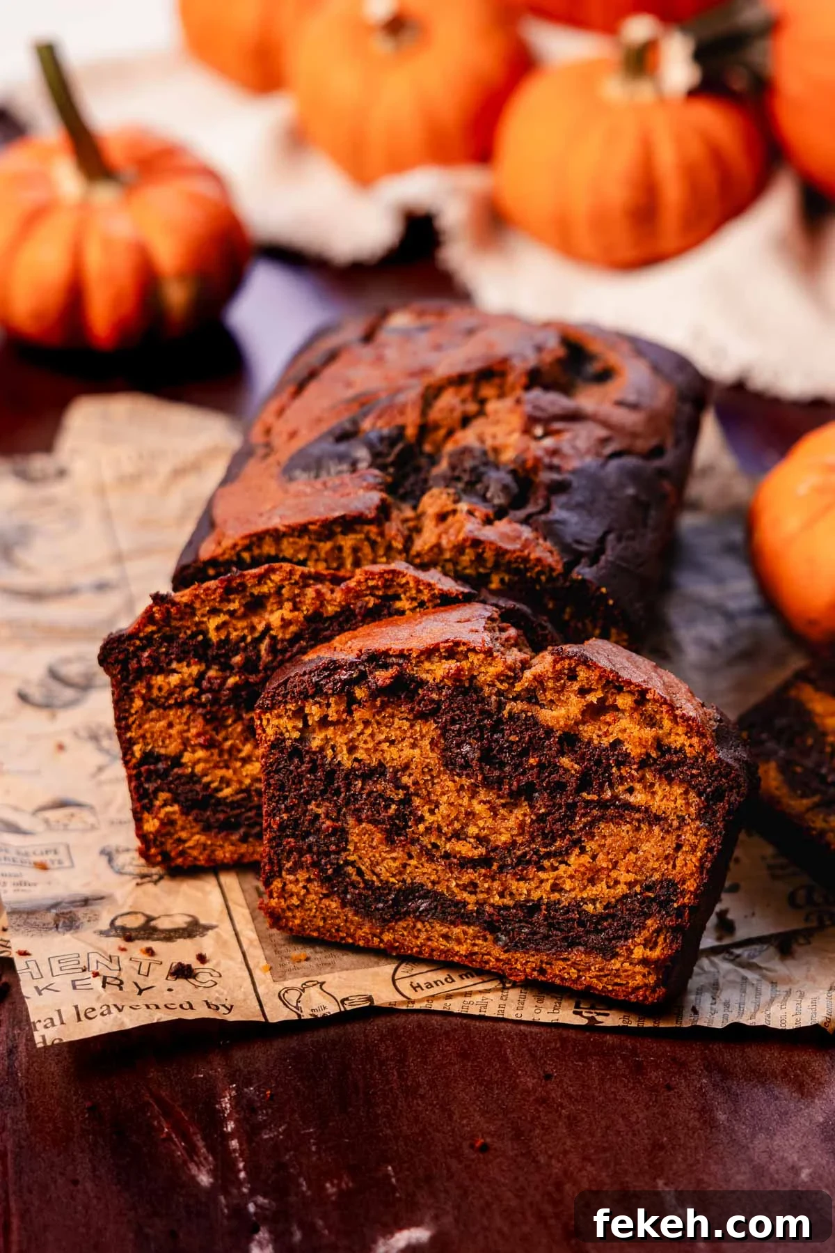 Pumpkin Chocolate Loaf with Spiced Chocolate Chips 3 slices of pumpkin and chocolate swirled bread on printed parchment paper