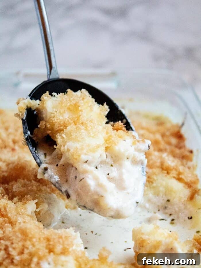 Low-Carb Keto Taco Salad Recipe for Quick Weeknight Meals 22 keto alfredo casserole with a large black spoon dipped into the dish