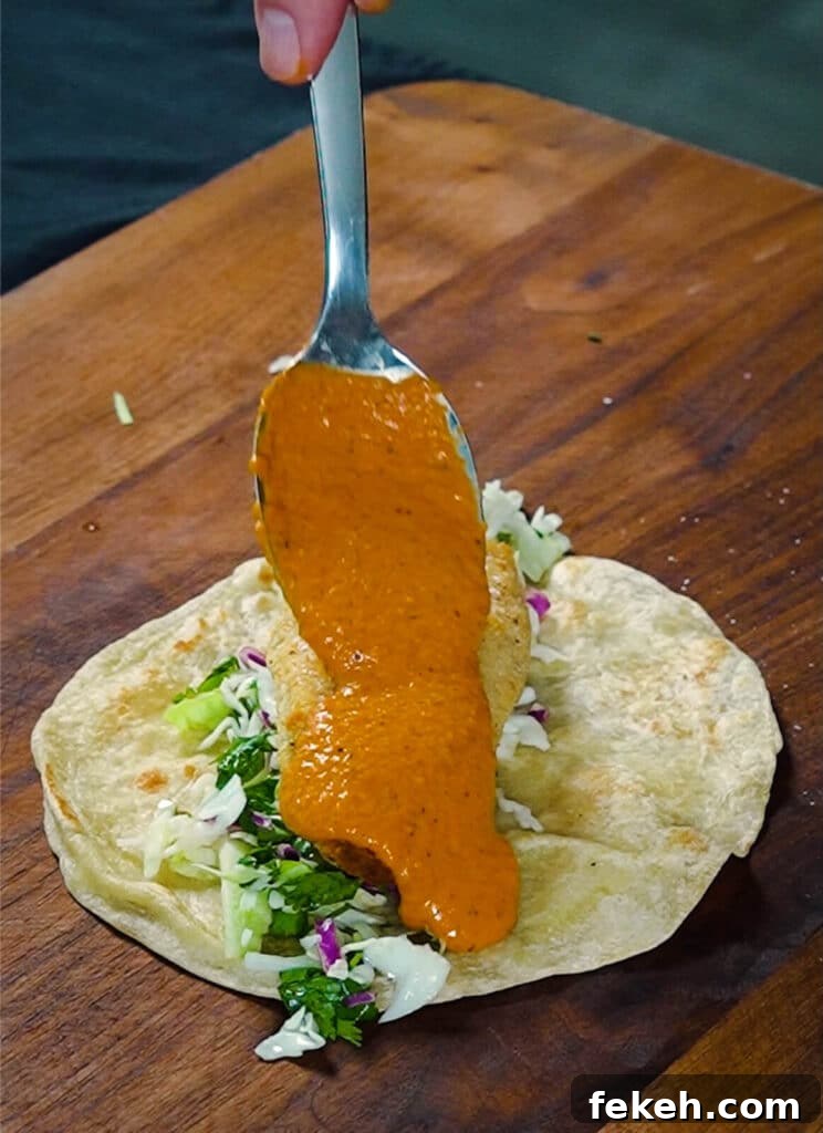 Chicken Tikka Masala Tacos Recipe — Fusion Indian Street Food 11 tikka masala sauce being added to a taco