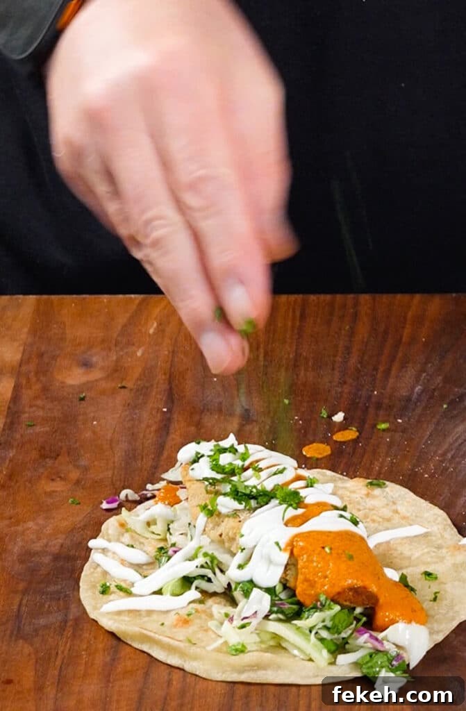 Chicken Tikka Masala Tacos Recipe — Fusion Indian Street Food 12 cilantro being added to a taco