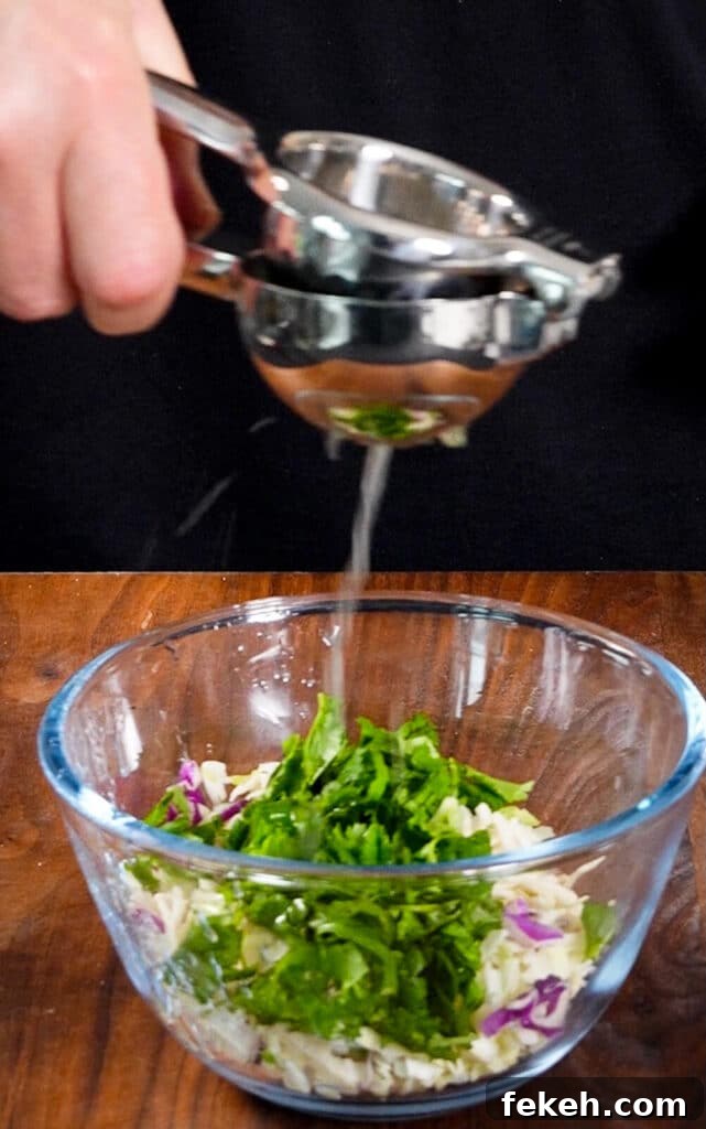 Chicken Tikka Masala Tacos Recipe — Fusion Indian Street Food 9 cabbage slaw in a bowl, lime juice being squeezed over it