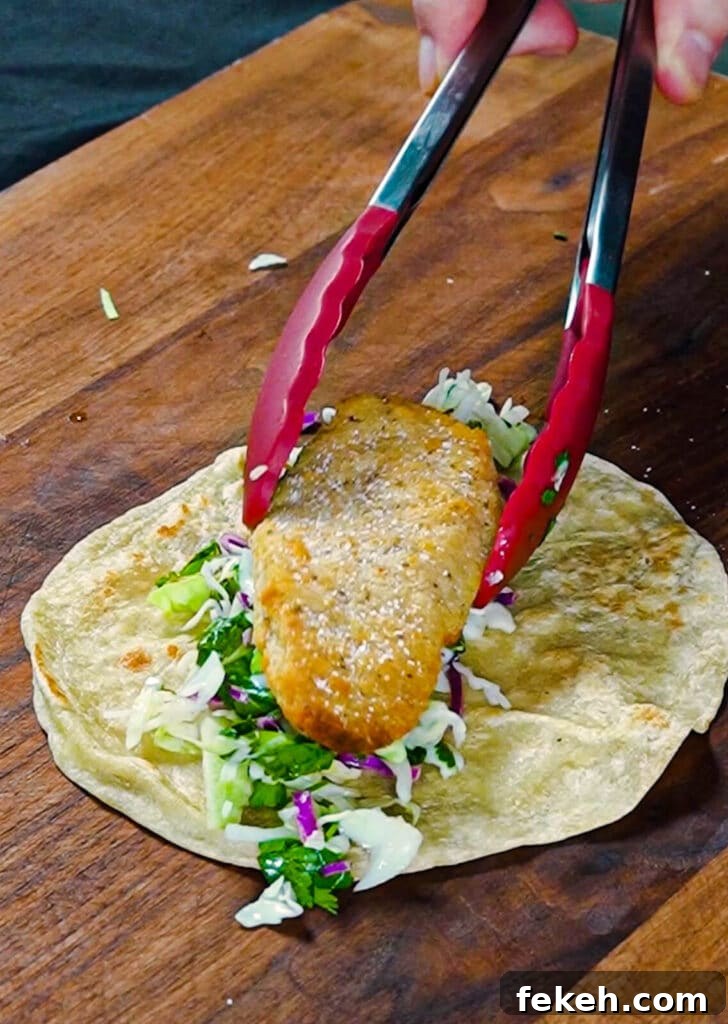 Chicken Tikka Masala Tacos Recipe — Fusion Indian Street Food 10 chicken tender being added to a taco