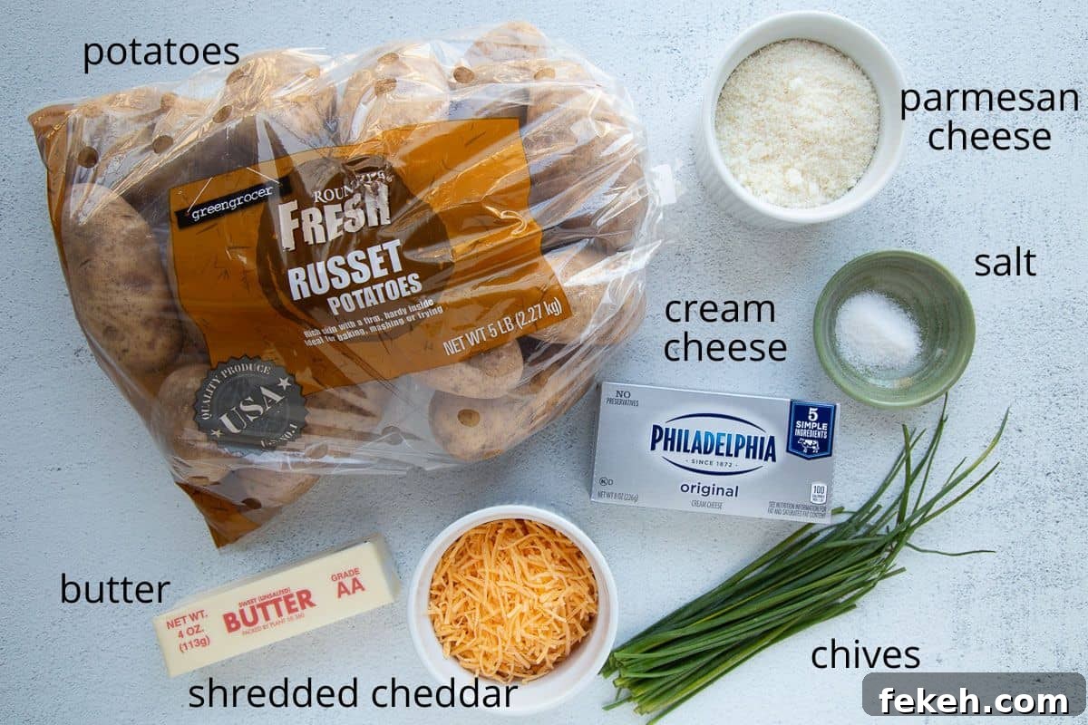 potatoes, cheddar, cream cheese, and other ingredients on a white table.