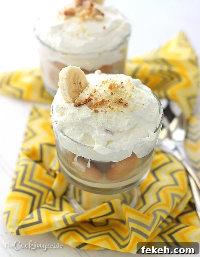 trifle bowl of banana pudding topped with whipped cream and crushed vanilla wafers