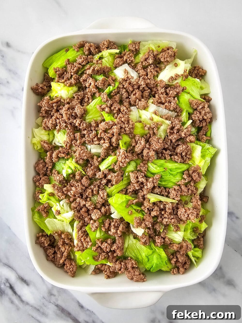 Keto Big Mac Salad: High-Protein Low-Carb Cheeseburger Bowl 9 chopped lettuce and ground beef in a casserole dish