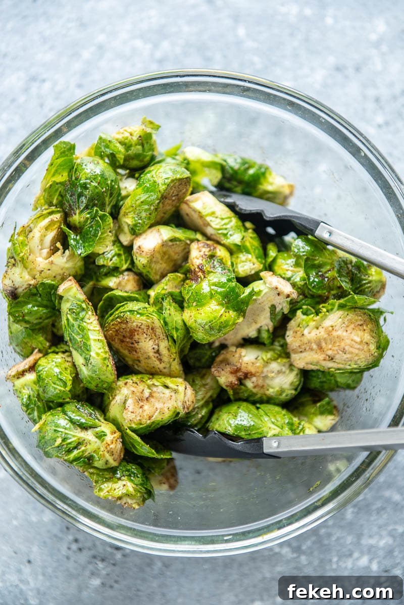 Crispy Spicy Brussels Sprouts with Garlic and Chili 4 brussels sprouts and seasonings in bowl with tongs