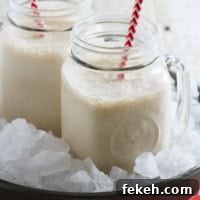 Root Beer Float Smoothie Recipe — Creamy Soda Dessert Drink 4 Two jars filled with root beer float smoothie, each with a straw.