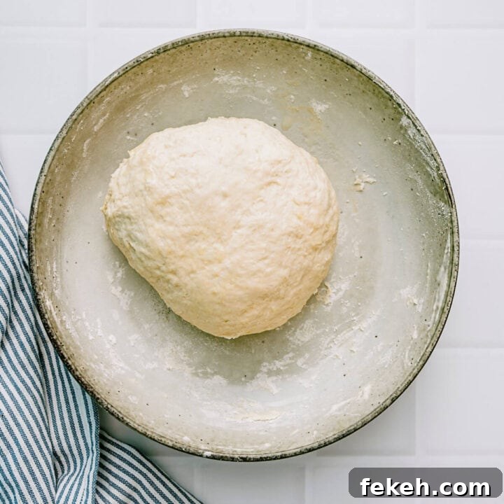 Authentic Greek Pita Bread Recipe: Soft, Foldable Pitas 6 Soft pita dough resting in a bowl after kneading.