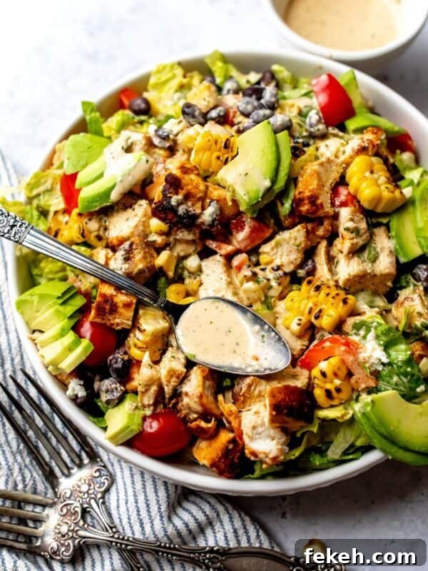 Creative Pizza Bowl Recipes: Flavorful Mini Pizza Bowls for Any Meal 11 Spicy Southwest Salad in a white bowl on a counter with a towel to the side.