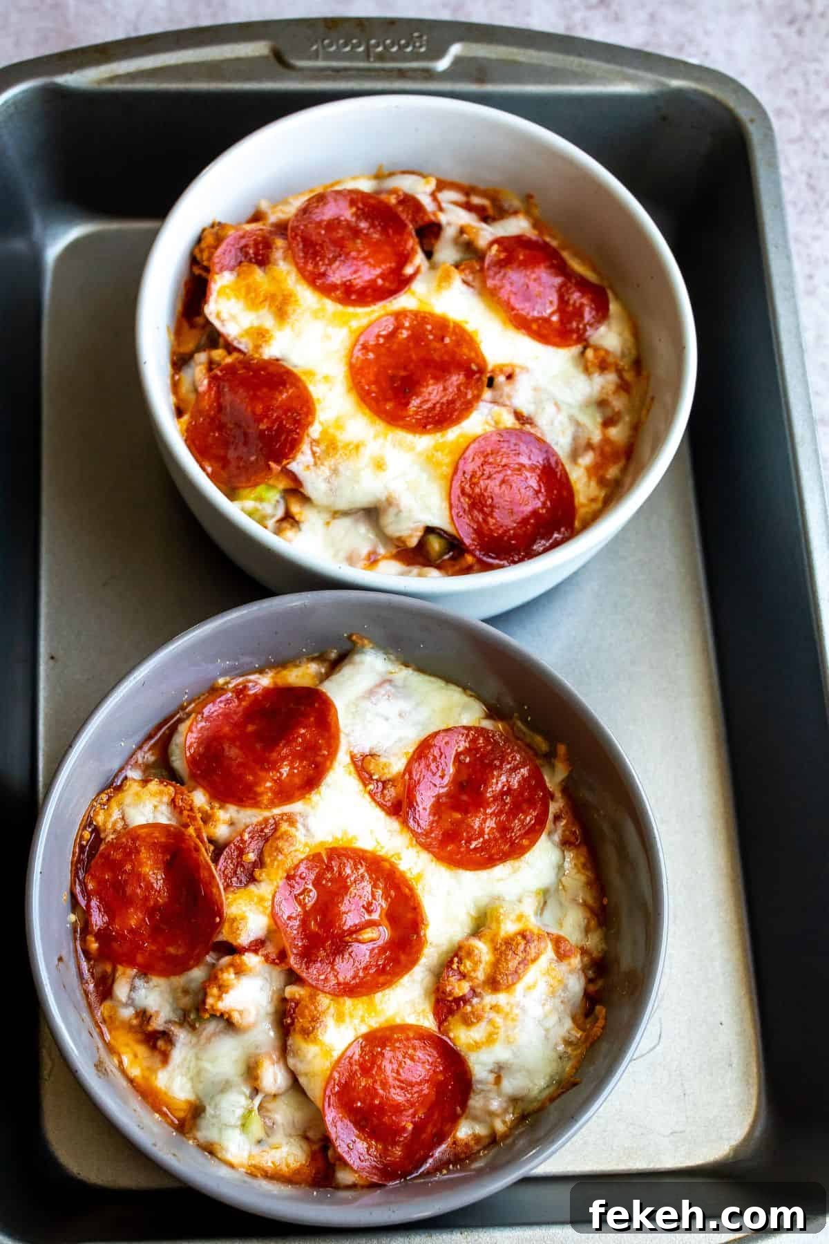 Creative Pizza Bowl Recipes: Flavorful Mini Pizza Bowls for Any Meal 6 Baking sheet with pizza bowls in them and pepperoni on top.