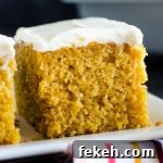 Irresistible Pumpkin Bars Recipe with Spiced Cream Cheese Frosting 2 pumpkin bar with cream cheese frosting on a white plate