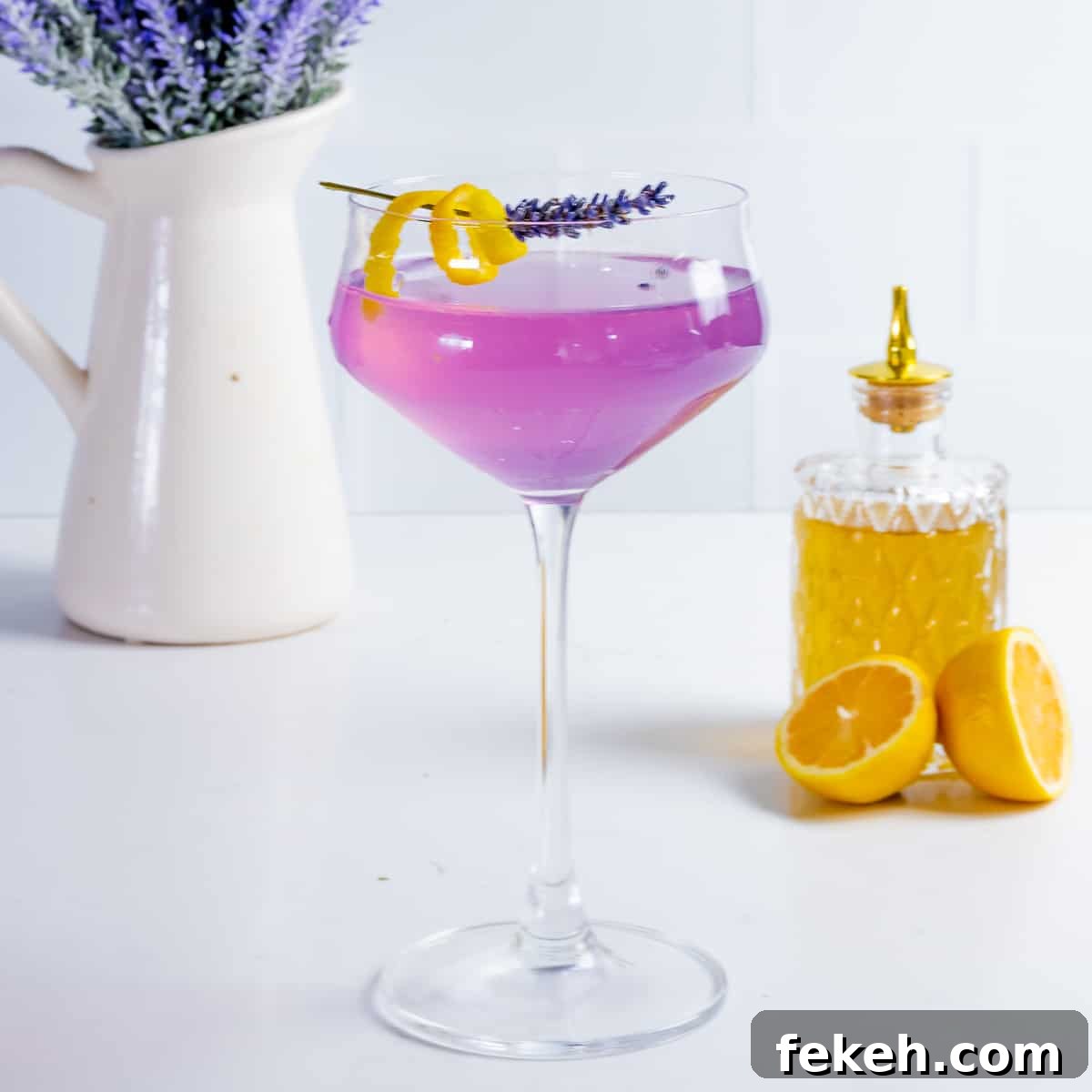 22 Elegant Cocktail Recipes for Sophisticated Events 4 Lavender martini cocktail with purple lavender flowers on table.