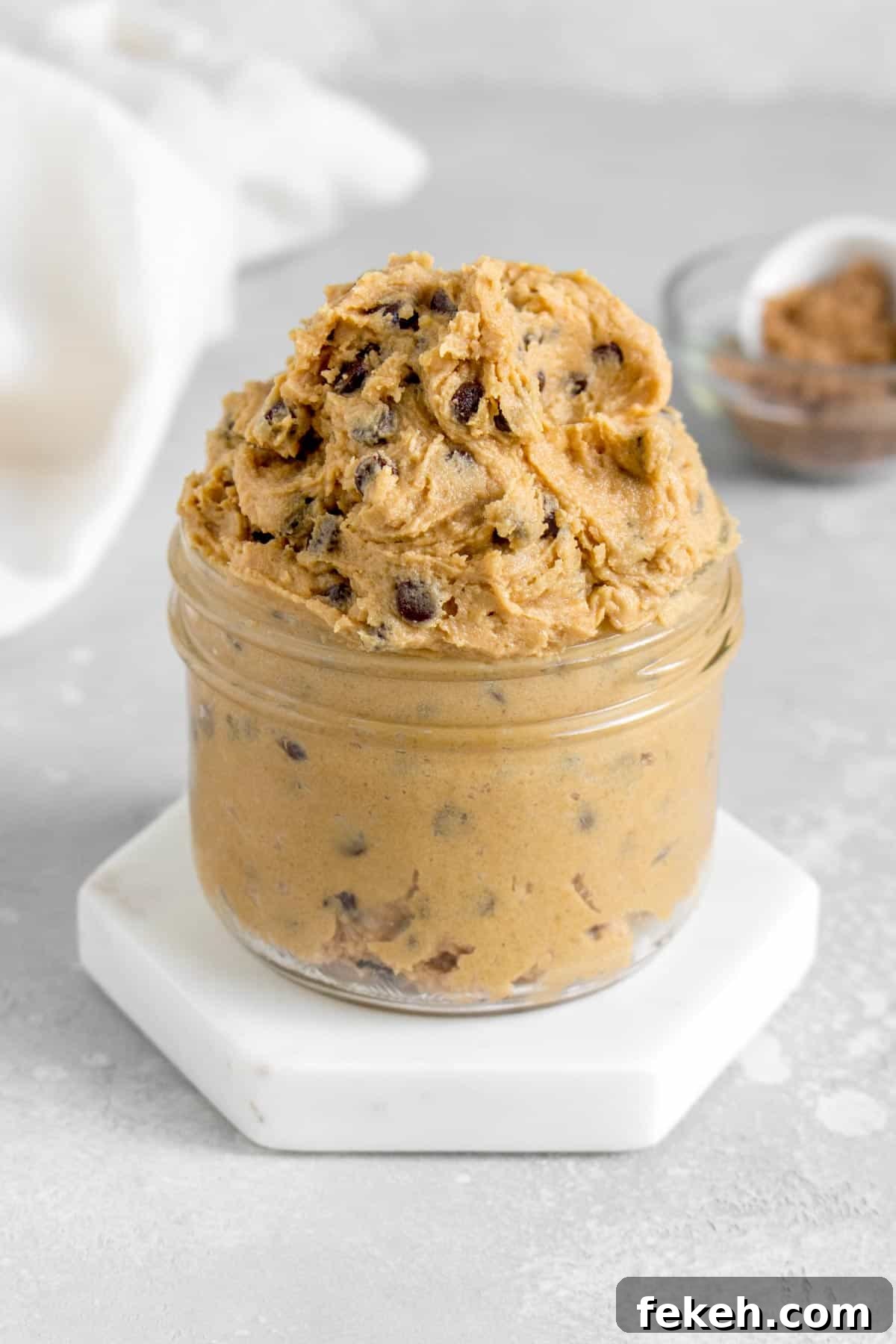 Safe-to-Eat Chocolate Chip Cookie Dough Recipe 3 A jar overflowing with edible chocolate chip cookie dough.