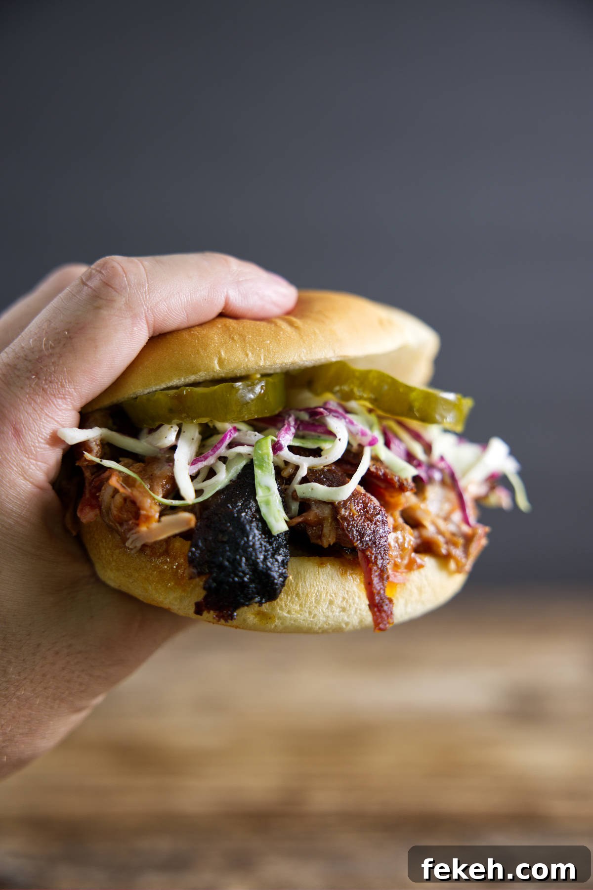 Smoked Pork Butt (Smoked Pork Shoulder) Recipe for Tender, Juicy Meat 2 Pulled pork sandwich made from smoked pork butt (smoked pork shoulder). With pickles, slaw, and BBQ sauce.