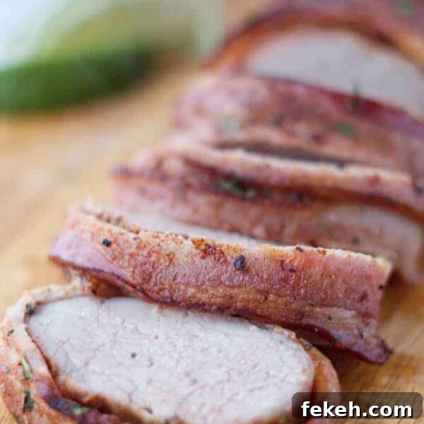 Smoked Pork Butt (Smoked Pork Shoulder) Recipe for Tender, Juicy Meat 17 Bacon wrapped pork tenderloin cut into slices on wood cutting board with cilantro and lime garnish