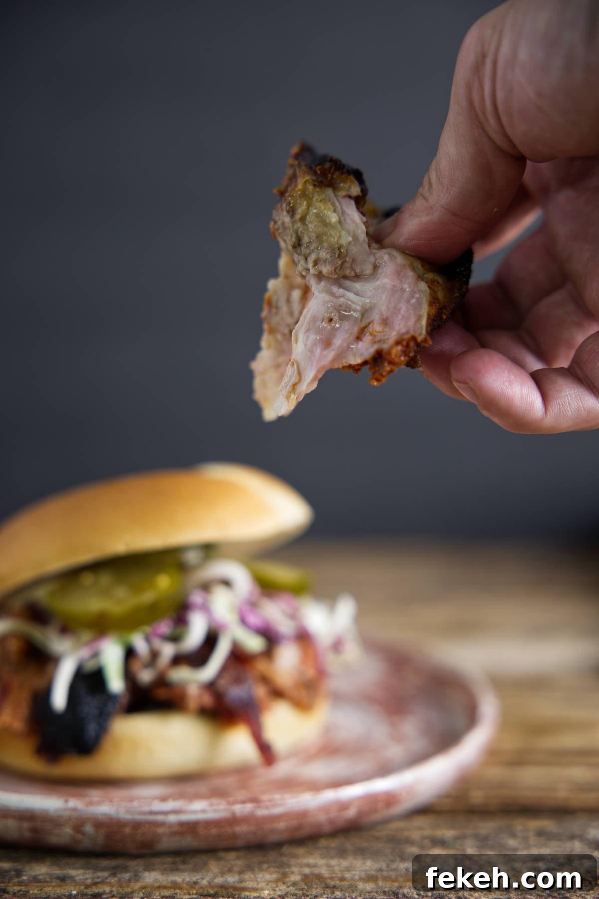 Smoked Pork Butt (Smoked Pork Shoulder) Recipe for Tender, Juicy Meat 27 Chunk of pulled pork above pulled pork sandwich.