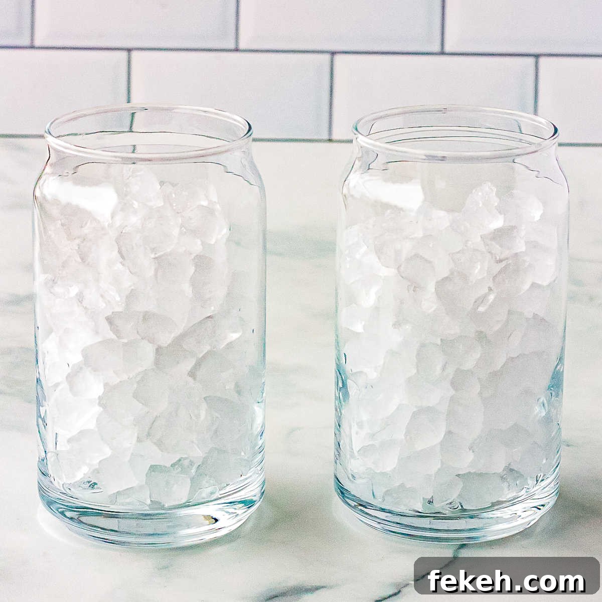 Pebble ice in two clear drinking glasses.