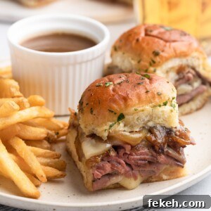 french dip sliders on a plate with french fries and a cup of jus