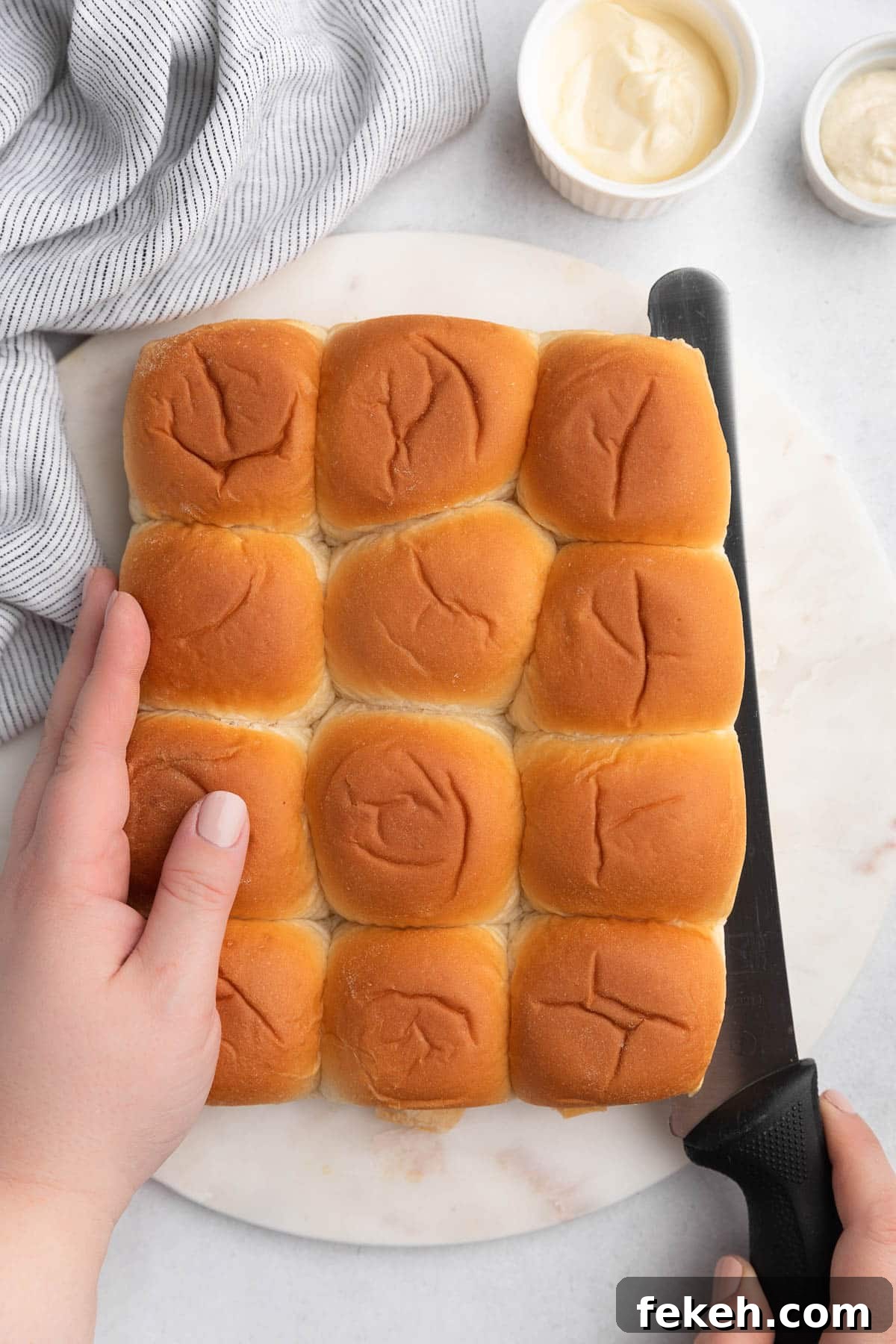 slider rolls being sliced on a white marble board