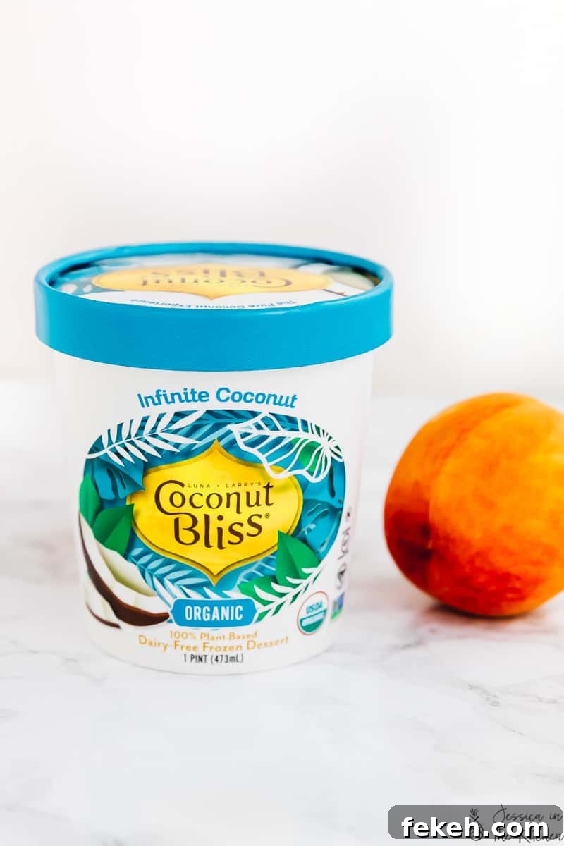 A tub of Coconut Bliss vegan ice cream next to a fresh peach.