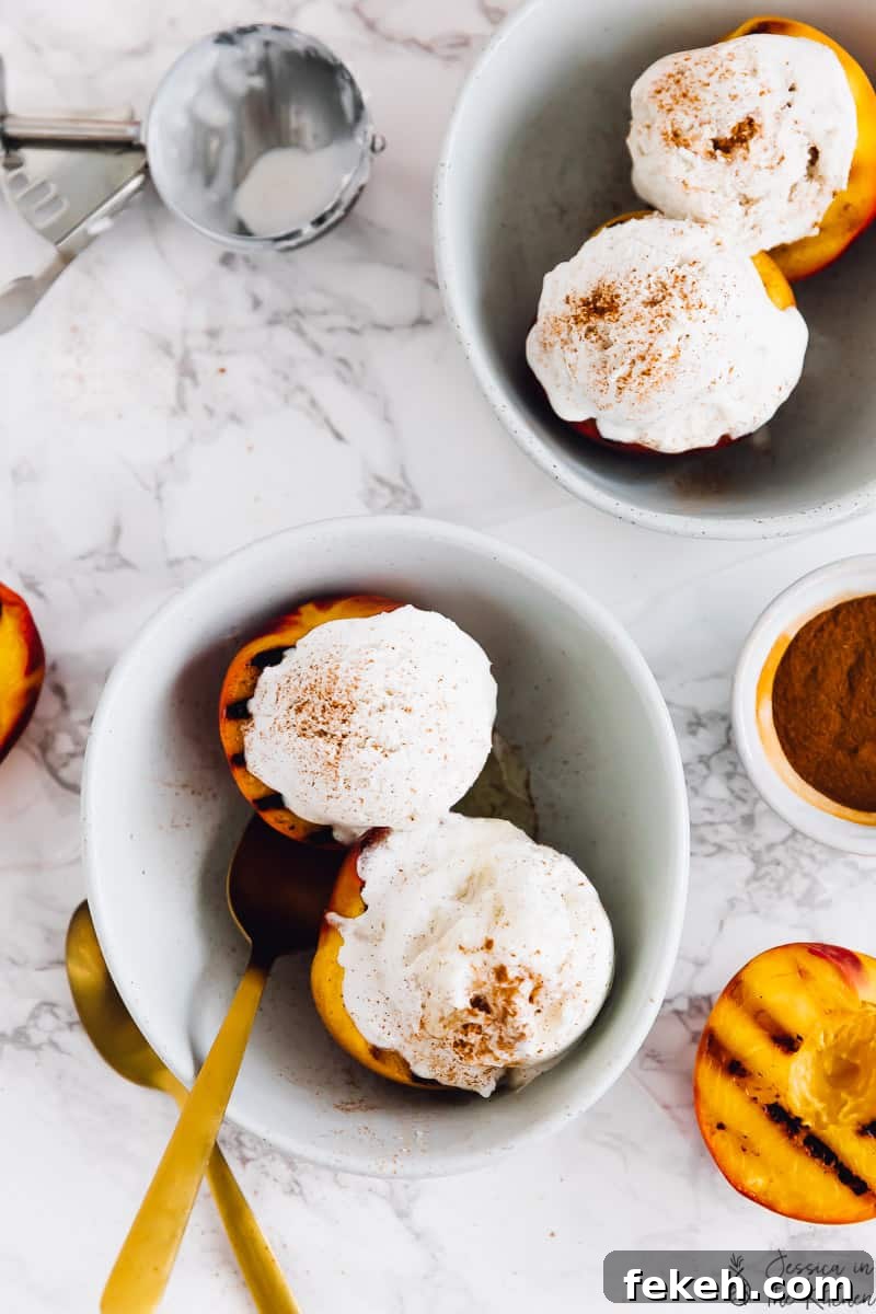 Overhead view of grilled peaches and ice cream in bowls, next to one half of a grilled peach.