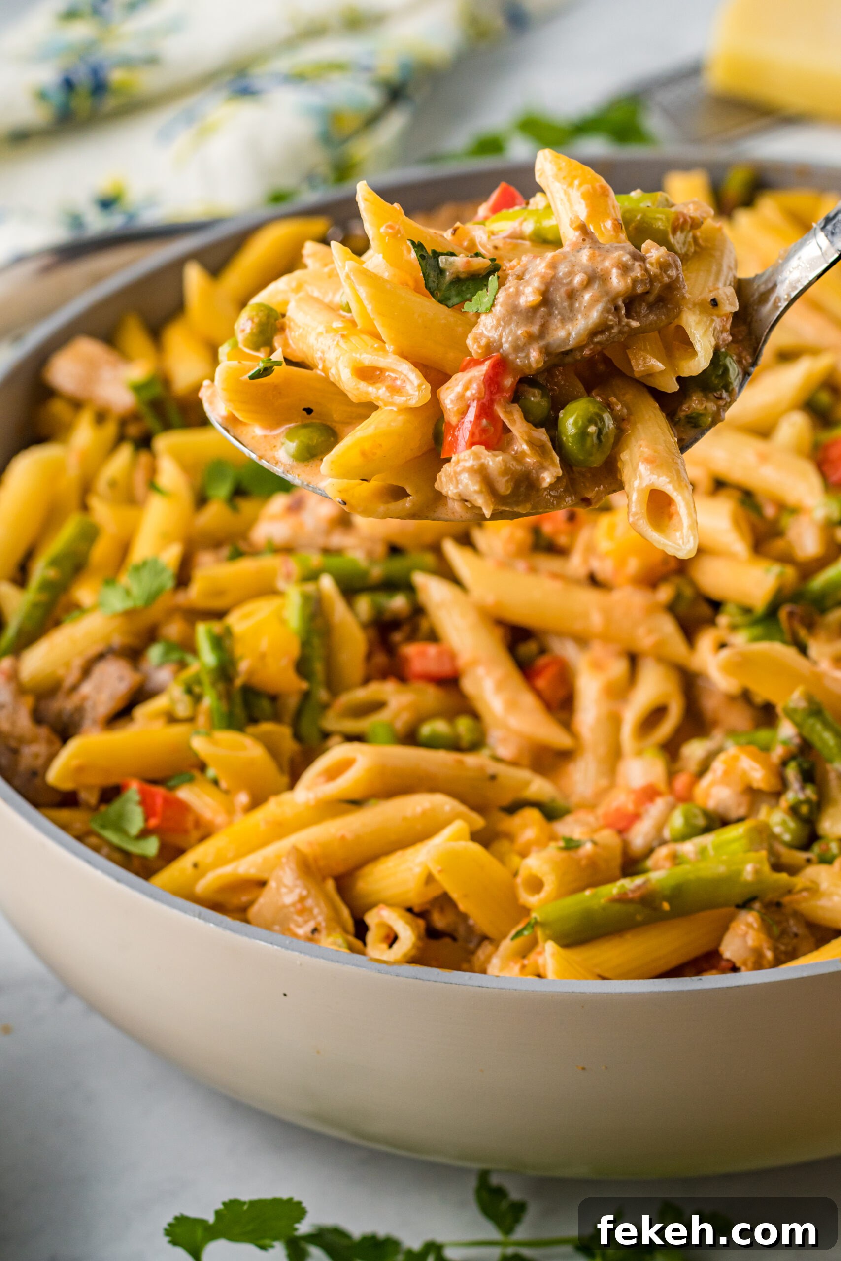 Cajun Chicken Pasta Recipe with Creamy Parmesan Sauce 5 Side view of Cajun Chicken Pasta with a large spoon scooping out a bite