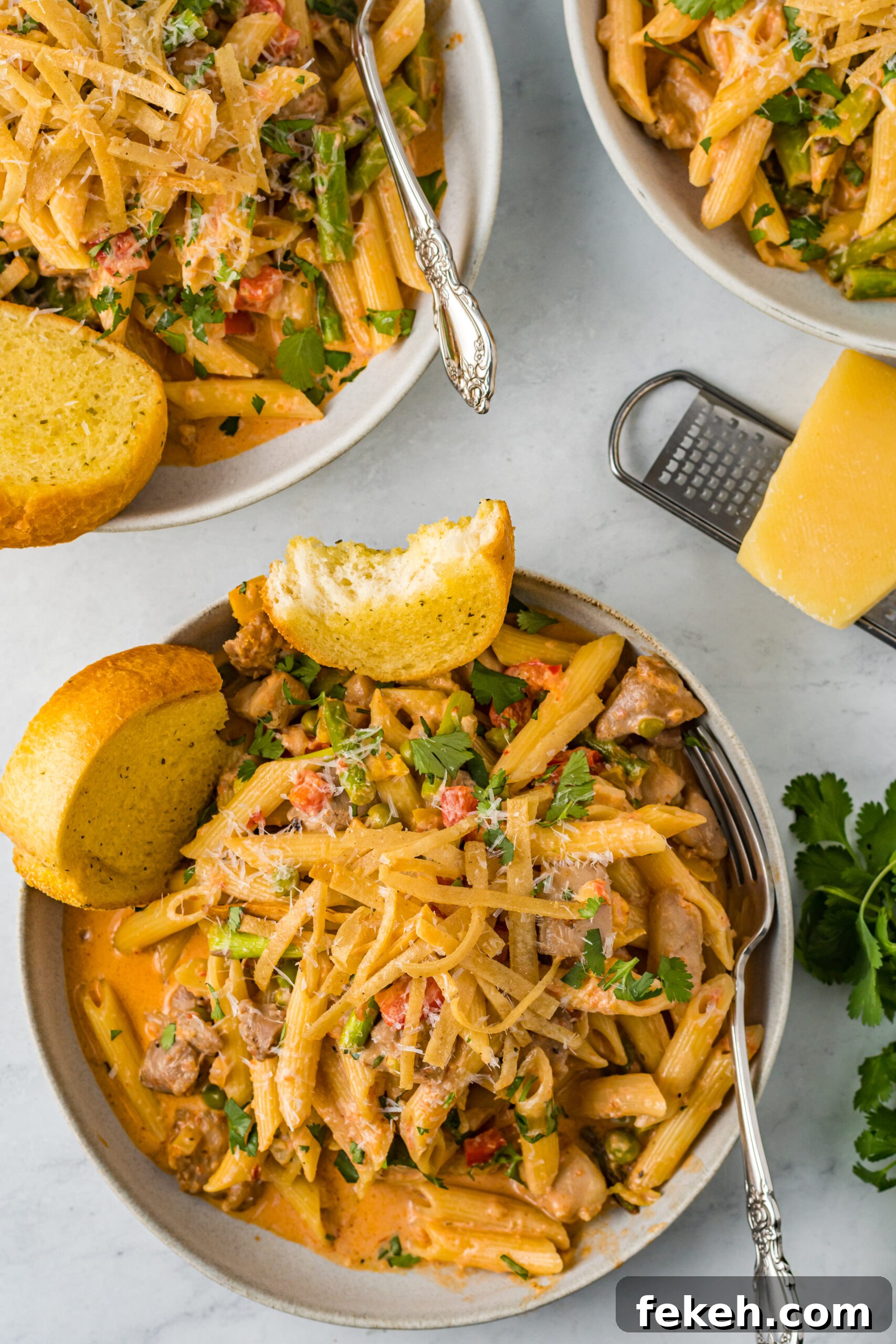 Cajun Chicken Pasta Recipe with Creamy Parmesan Sauce 9 Overhead view of Cajun Chicken Pasta served in a dish with garlic bread.