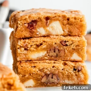 Chewy Blonde Brownies Recipe: Soft, Buttery Bars 2 A stack of three blonde brownies with white chocolate chips and pecans visible.