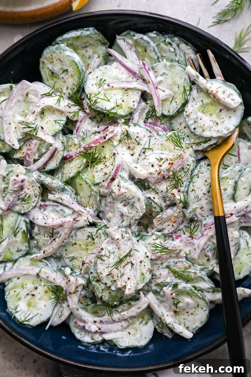 Creamy Cucumber Salad with Tangy Greek Yogurt Dressing 7 A close up photo of creamy cucumber salad tossed in a tzatziki-style Greek yogurt dressing topped with fresh dill and cracked black pepper