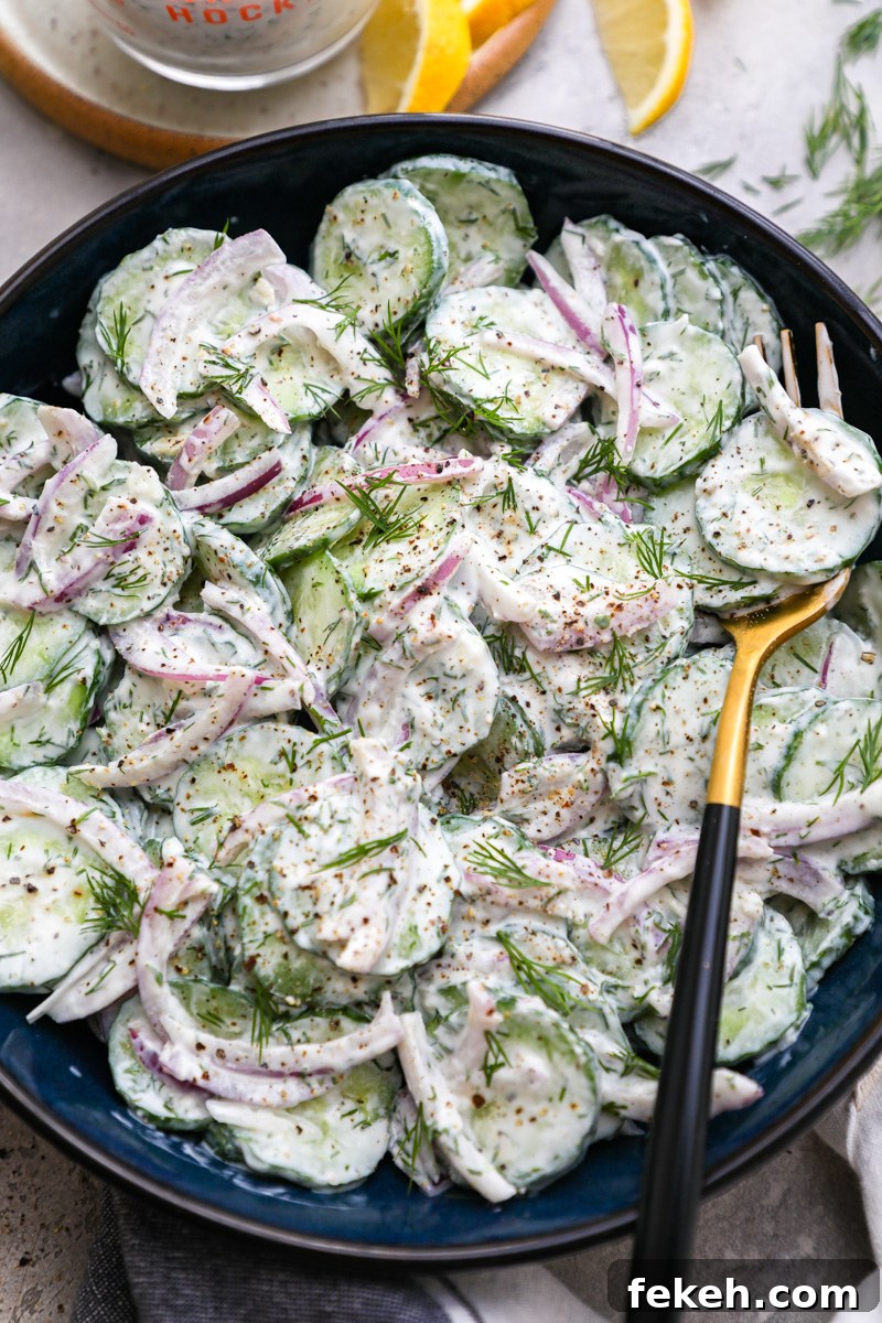 Creamy Cucumber Salad with Tangy Greek Yogurt Dressing 8 A small serving bowl filled with creamy cucumber salad topped with fresh dill and cracked black pepper