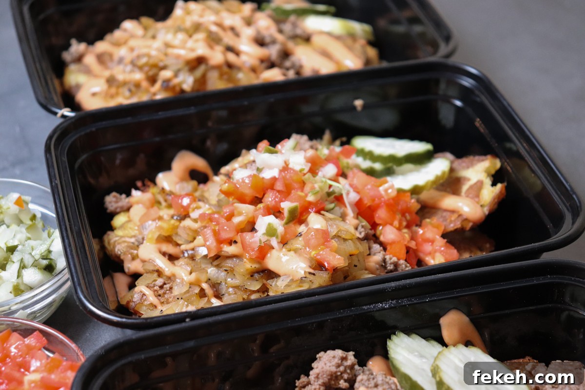 Animal-Style Burger Bowls: Low-Carb Cheeseburger Skillet Bowl 7 Animal style burger bowls showing meal prep containers loaded with smashed potatoes, ground beef, caramelized onions, topped with pickles, diced onions, tomatoes, and sauce.