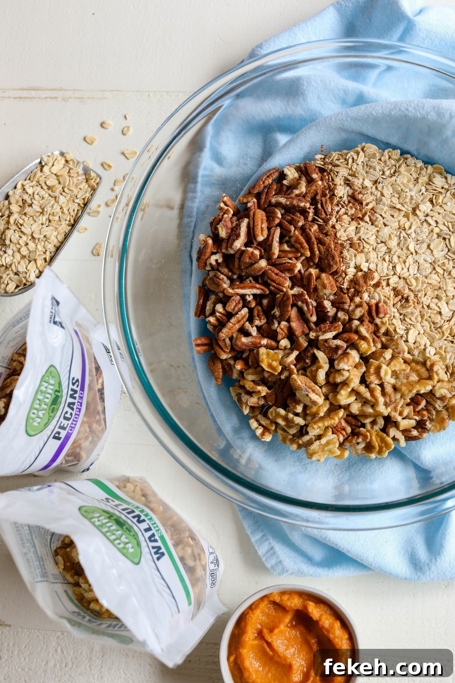 Sweet Potato Spice Granola Recipe for Cozy Fall Mornings 5 dry granola ingredients in bowl with blue towel underneath