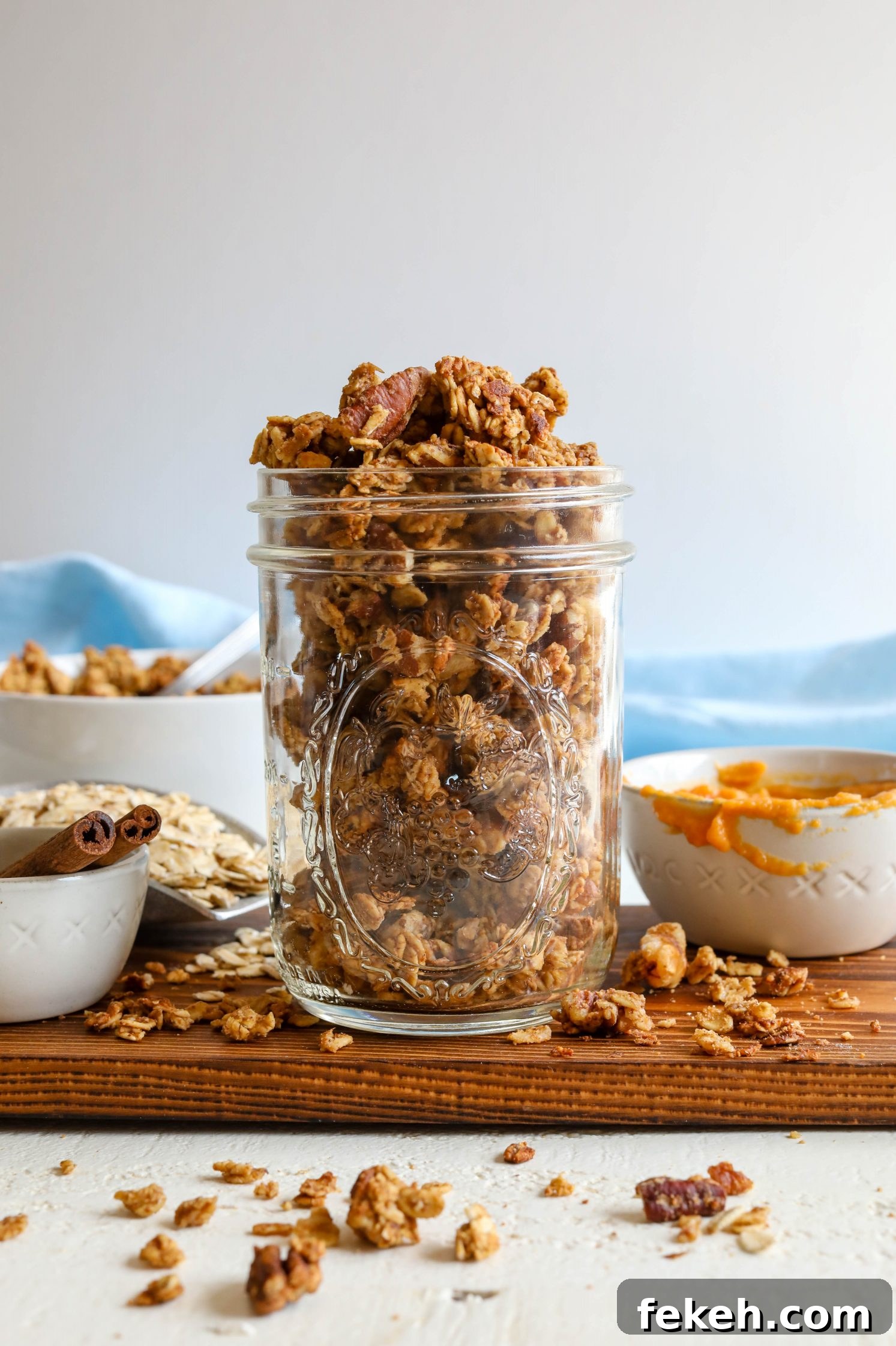 Sweet Potato Spice Granola Recipe for Cozy Fall Mornings 9 Sweet Potato Spice Granola served in mason jar with sweet potato puree on the side with blue towel and cinnamon