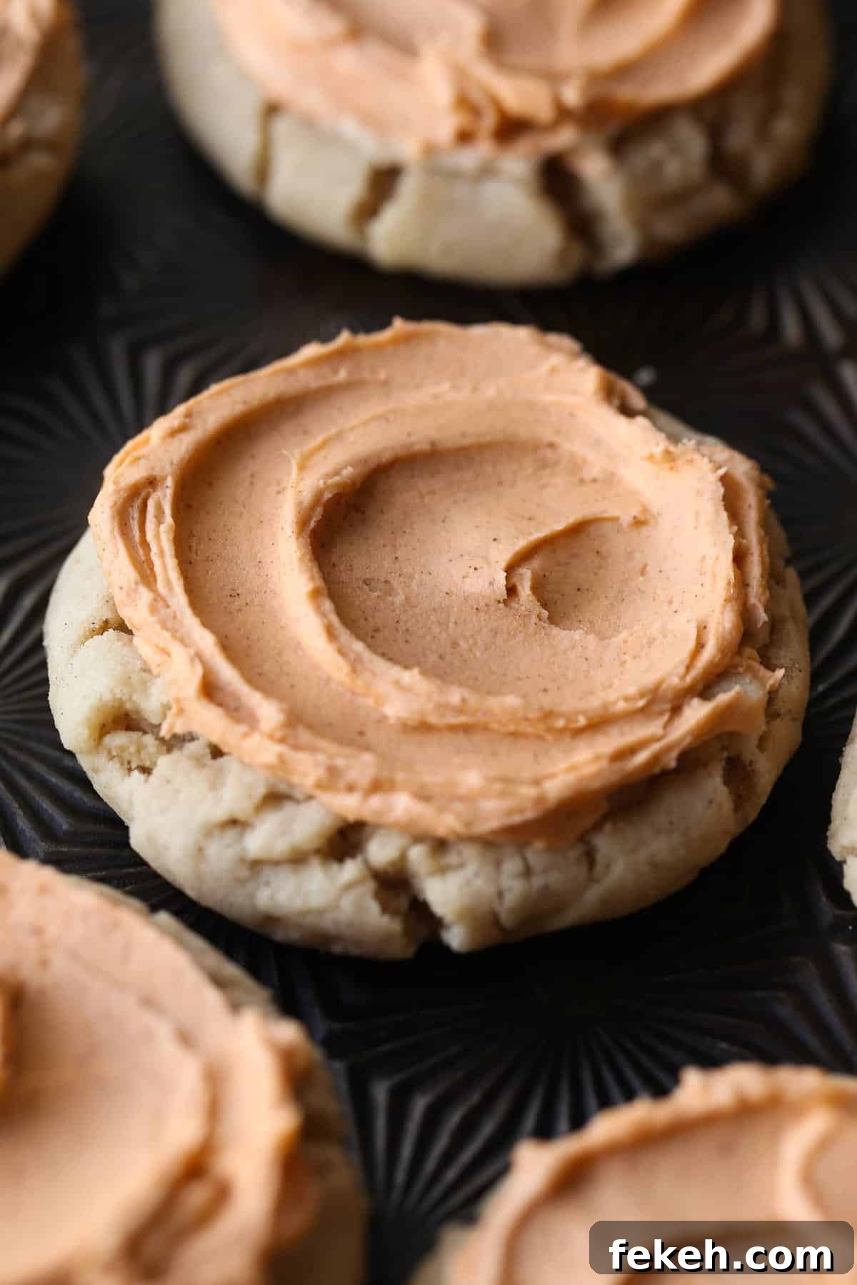 Browned butter frosting covering a pumpkin spice cookie Browned butter frosting covering the top of a pumpkin spice sugar cookie