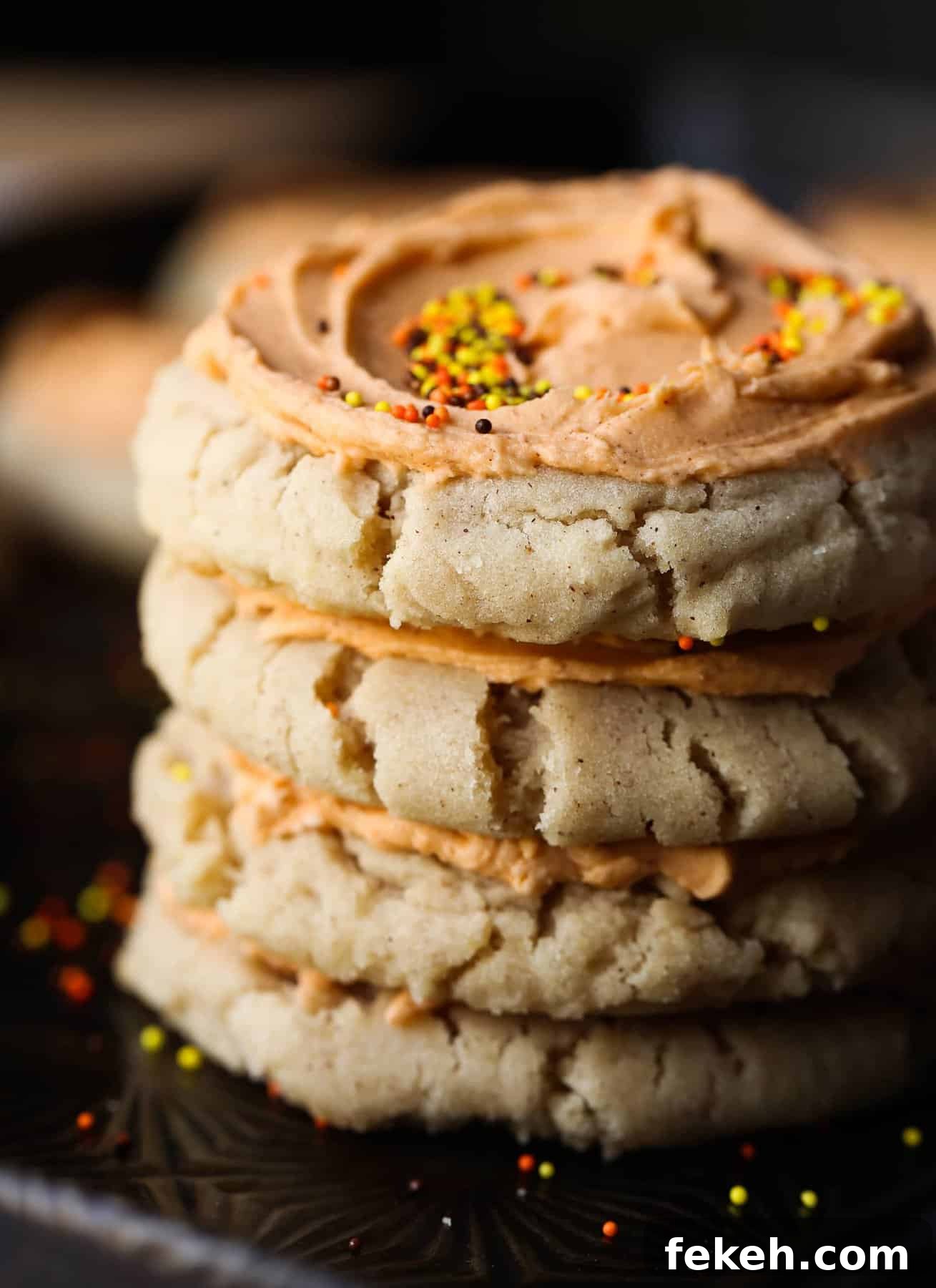 Stack of frosted pumpkin spice sugar cookies A stack of Pumpkin Spice Sugar Cookies topped with browned butter frosting and sprinkles