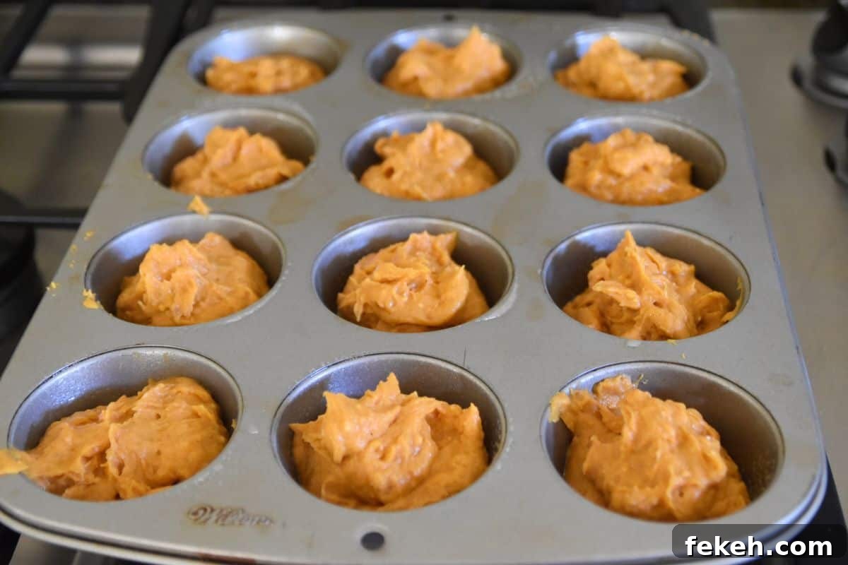 Low-Calorie Pumpkin Muffins for Weight Watchers-Friendly Diet 5 pumpkin muffin batter in a muffin pan