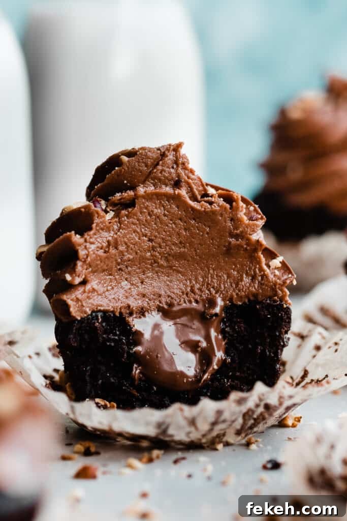 Nutella Chocolate Cupcakes with Cream Cheese Nutella Frosting 8 A close-up on a nutella cupcake with a bite missing and nutella running out of the center.