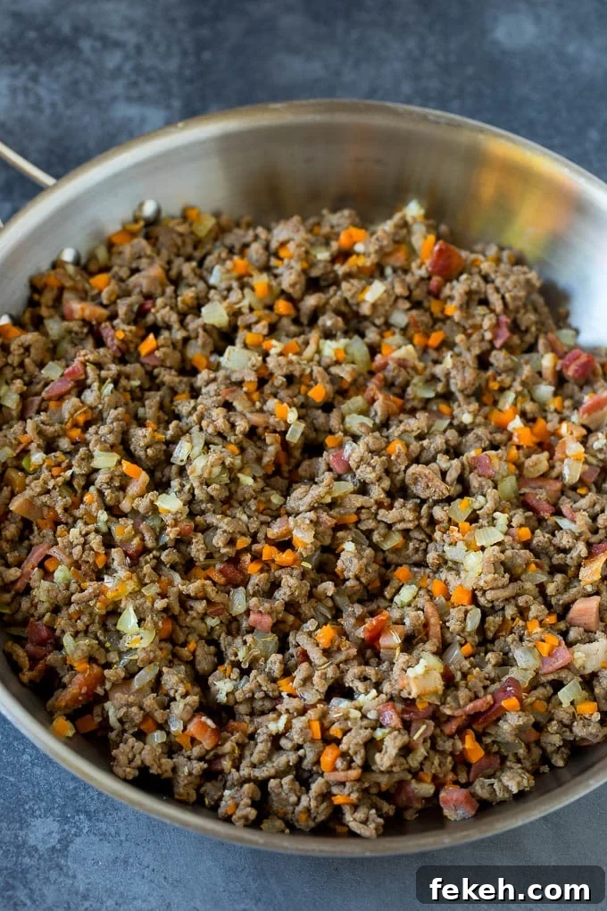 Pasta bolognese with spaghetti tossed in the most delicious homemade meat sauce. Meat and diced vegetables cooked together in a pan.