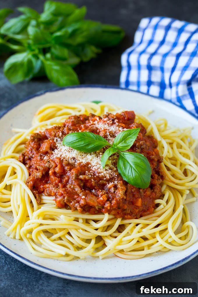 Pasta bolognese with spaghetti tossed in the most delicious homemade meat sauce. A plate of pasta bolognese topped with parmesan cheese and fresh basil.