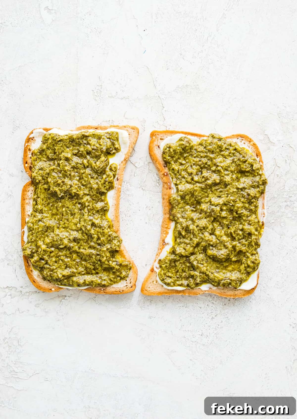 Grilled Turkey and Pesto Sandwich Recipe 4 Two pieces of bread with pesto spread on them.