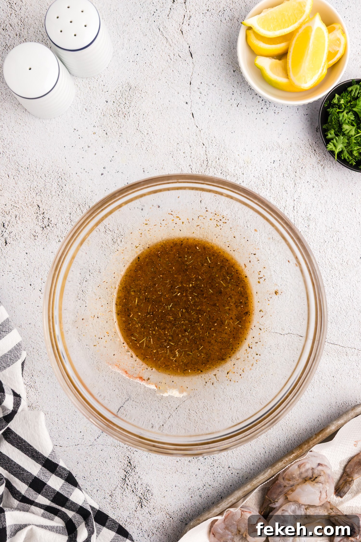 Seasoning mixture blended into a marinade inside a glass mixing bowl.