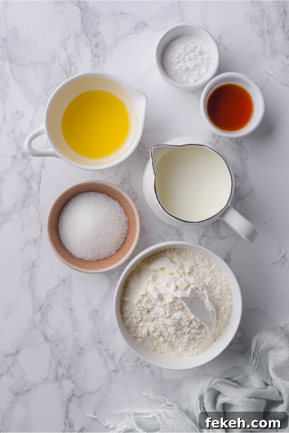Light and Fluffy Vegan Pancakes Without Eggs 4 An assortment of ingredients including bowls of flour, sugar, baking powder, vanilla extract, and melted butter.