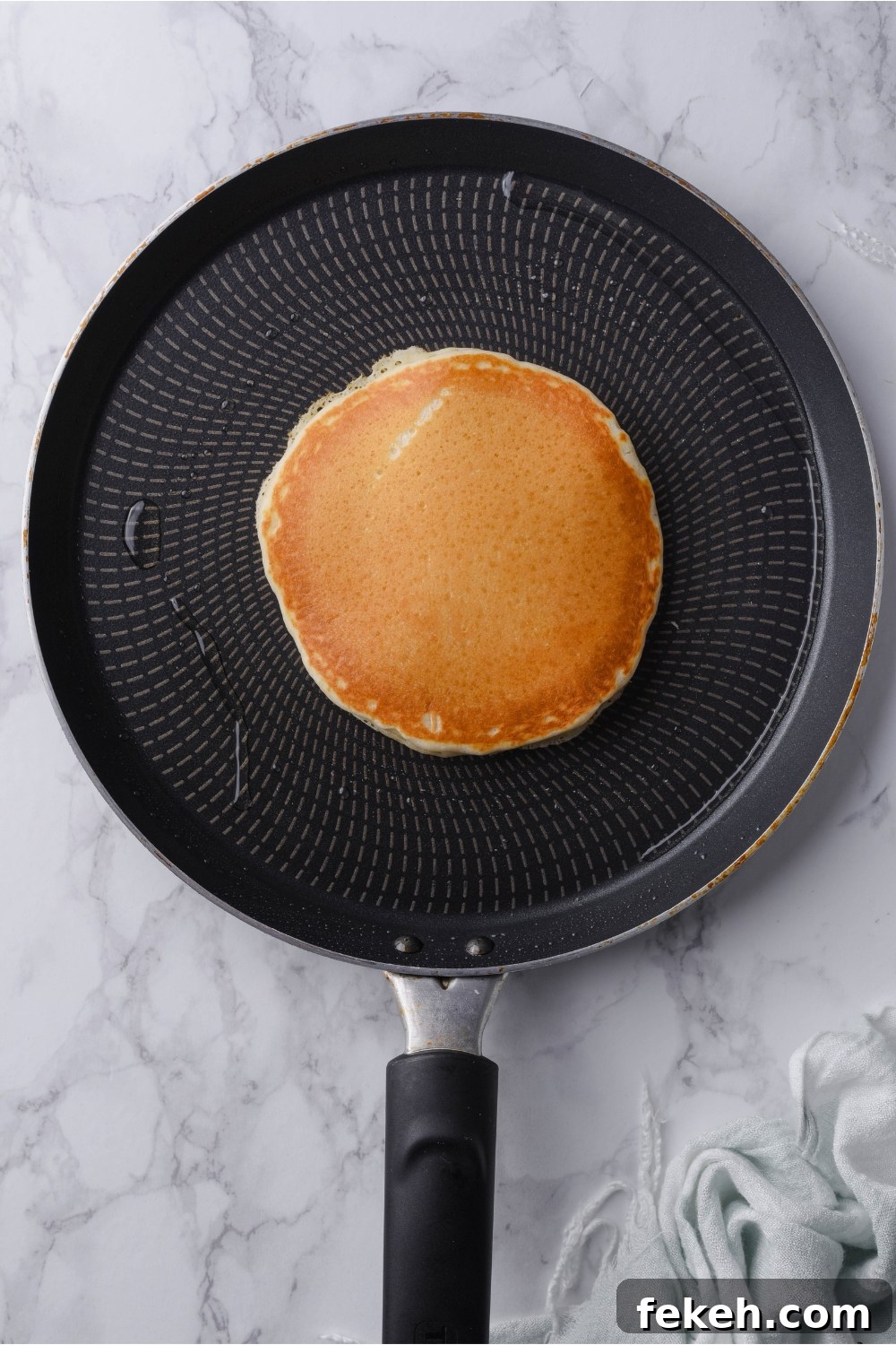 Light and Fluffy Vegan Pancakes Without Eggs 8 A griddle with a cooked pancake in the center.