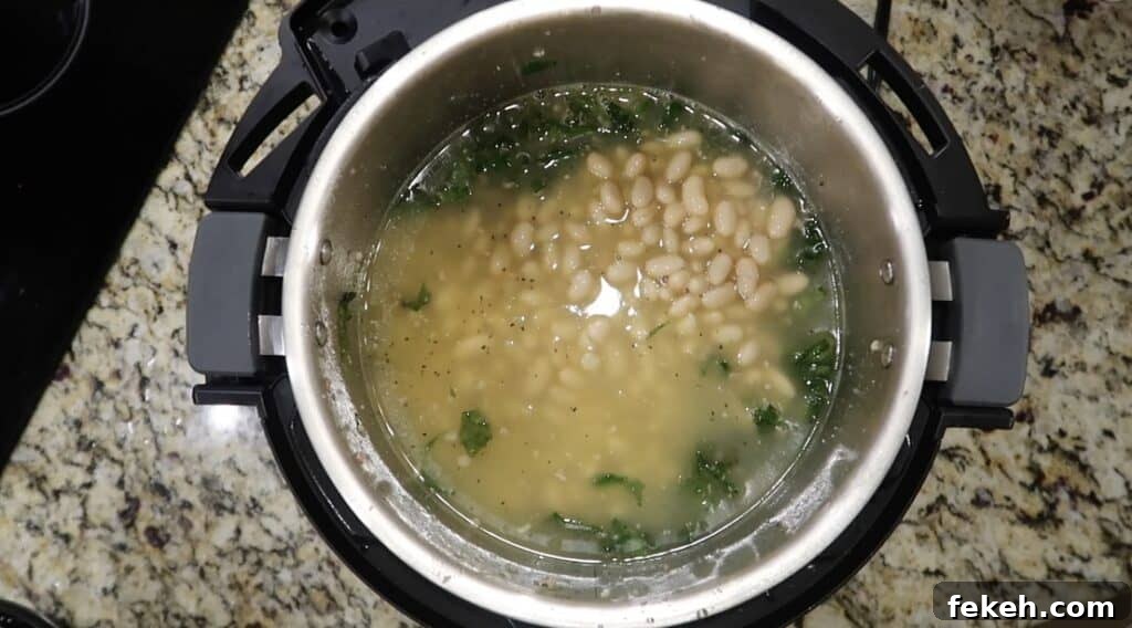 Instant Pot Escarole and White Bean Soup Recipe 18 Smoothing beans out in pot.