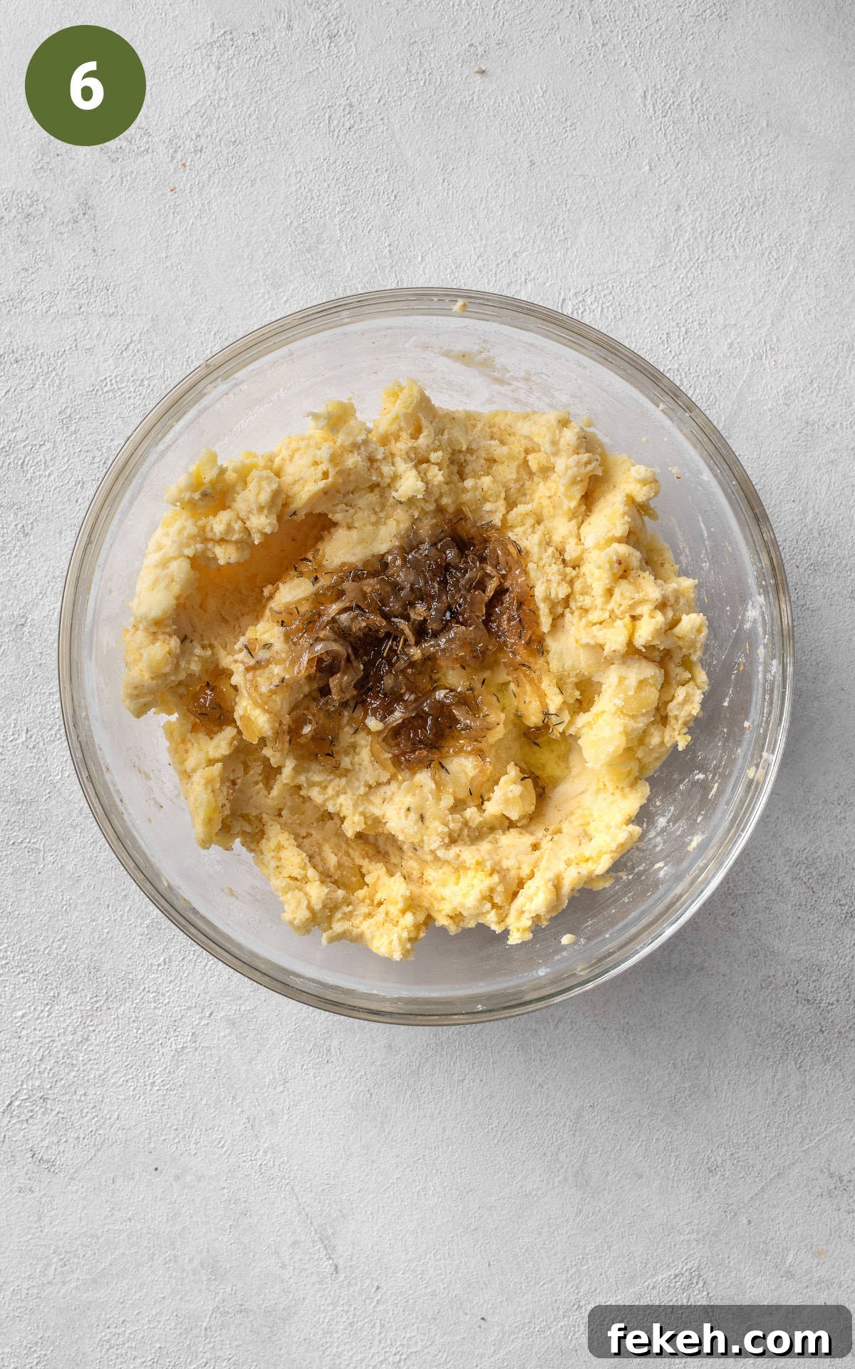 Cheesy Potato Pie Recipe: Crispy Crust & Melty Filling 9 adding grated cheddar cheese to the mixture.