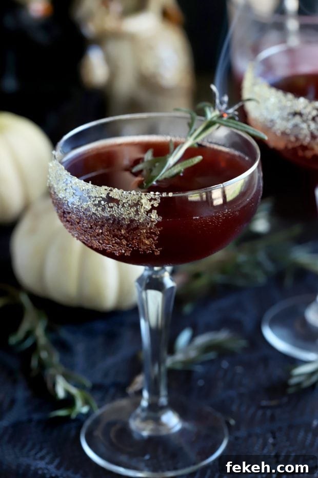 Pomegranate Mezcal Cocktail Recipe for Halloween Parties 4 Spooky Pomegranate Cocktail on the table with pumpkins and rosemary